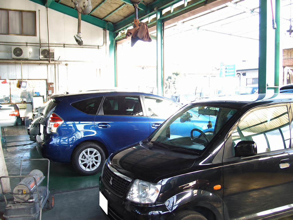 柏市西柏台の（株）鏑木自動車 柏の整備工場内に並ぶ黒色と青色の車両