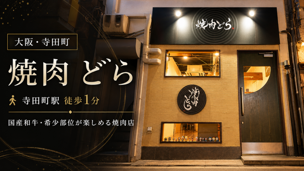 寺田町の焼肉店「焼肉 どら」の黒い看板と温かい照明が見える店舗外観