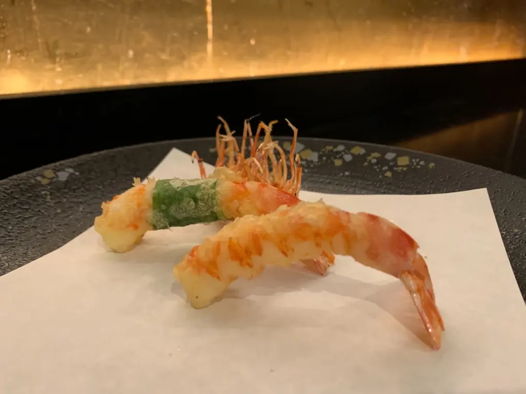なにわ天ぷら 維心の店内で提供される天ぷら料理とシャンパンを写した北新地の食事風景