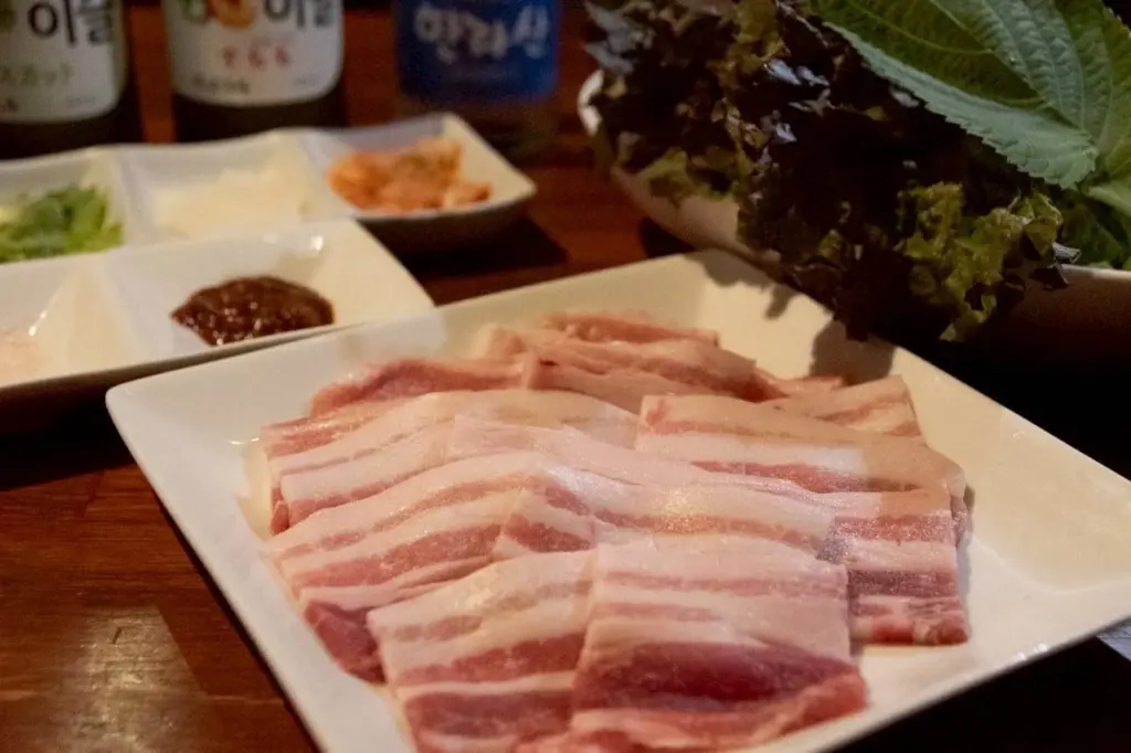 韓喰の店舗外観と韓国料理のサムギョプサル・もつ鍋を組み合わせた紹介画像