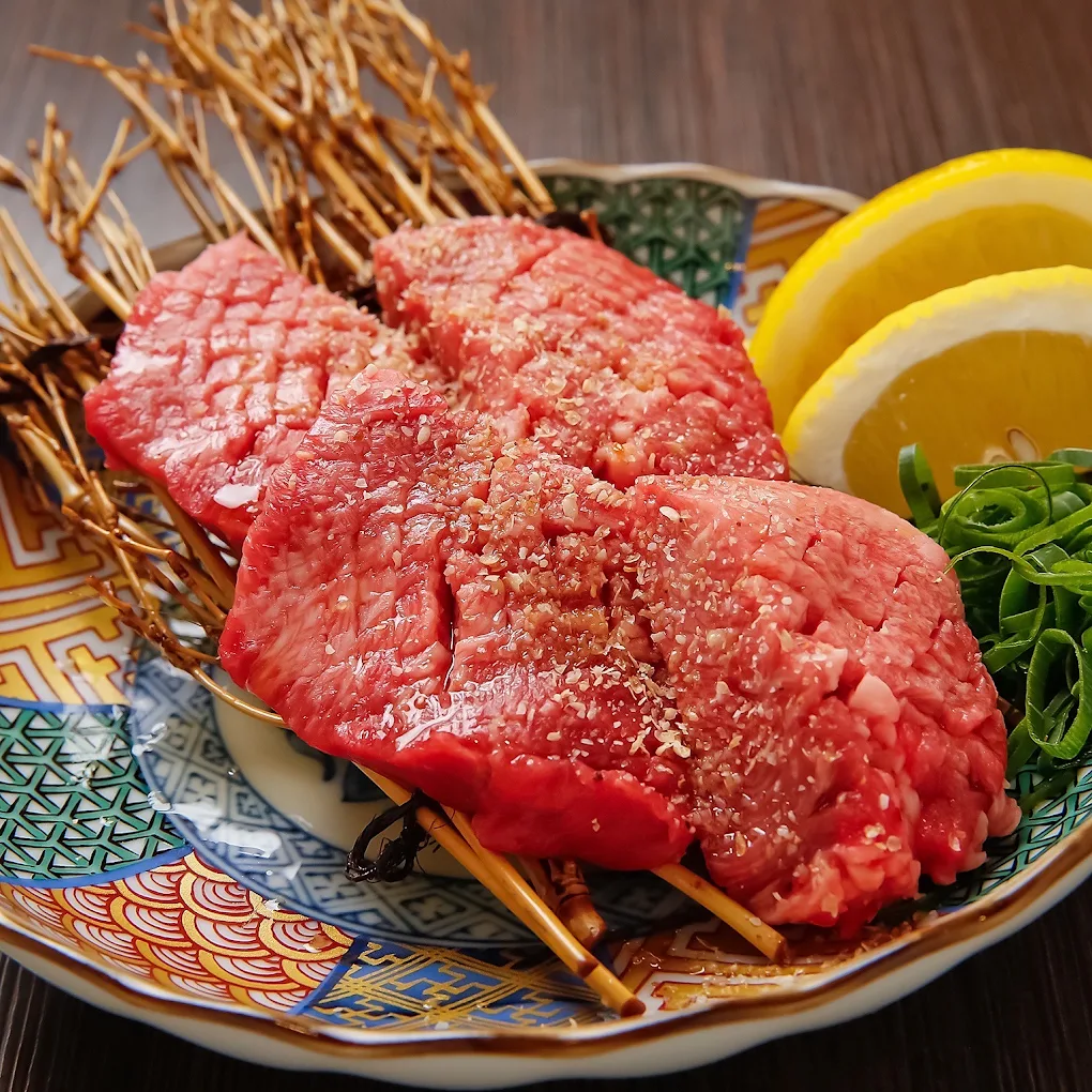 大阪難波の焼肉 錦の黒毛和牛料理と卵黄を華やかな器に盛り付けた料理写真