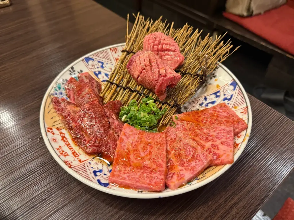 大阪難波の焼肉 錦の黒毛和牛料理と卵黄を華やかな器に盛り付けた料理写真