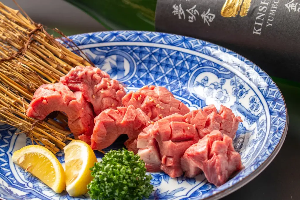 大阪難波の焼肉 錦の黒毛和牛料理と卵黄を華やかな器に盛り付けた料理写真