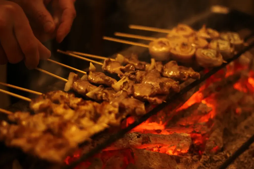 今泉の焼鳥居酒屋akariで備長炭の上に並ぶ焼鳥と串焼きの様子