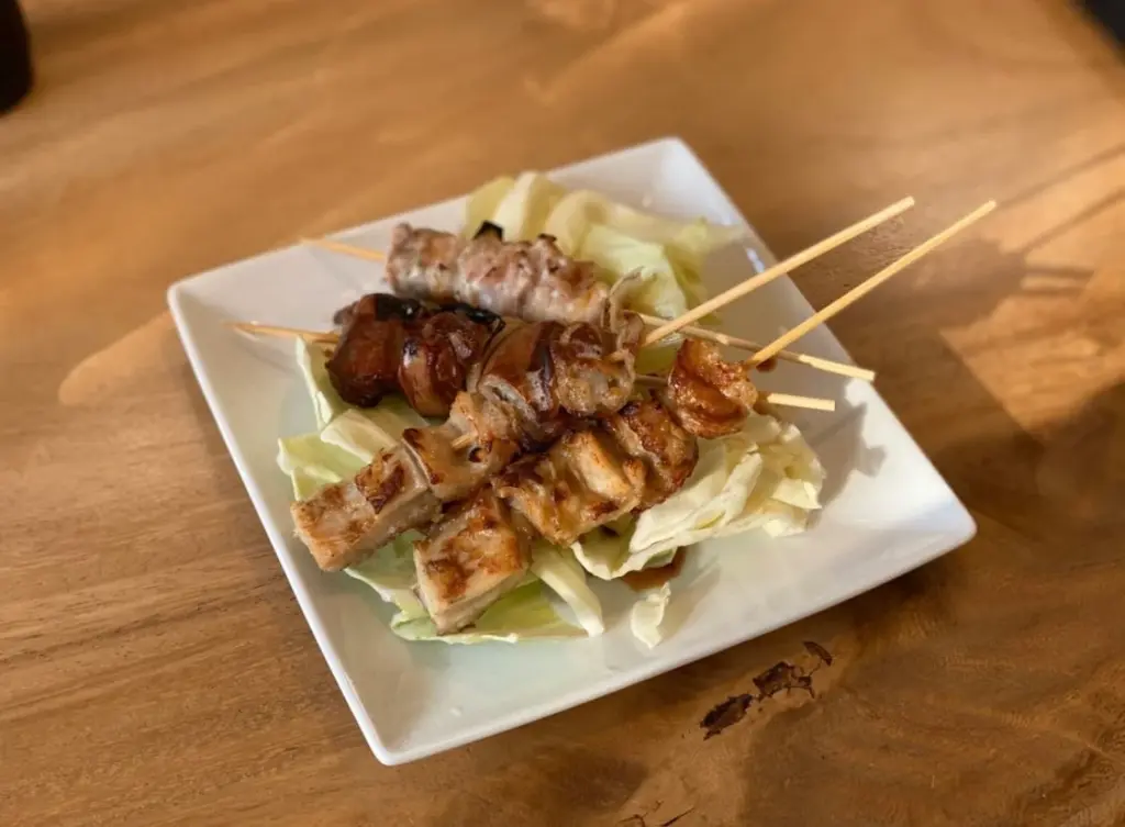 今泉の焼鳥居酒屋akariで備長炭の上に並ぶ焼鳥と串焼きの様子